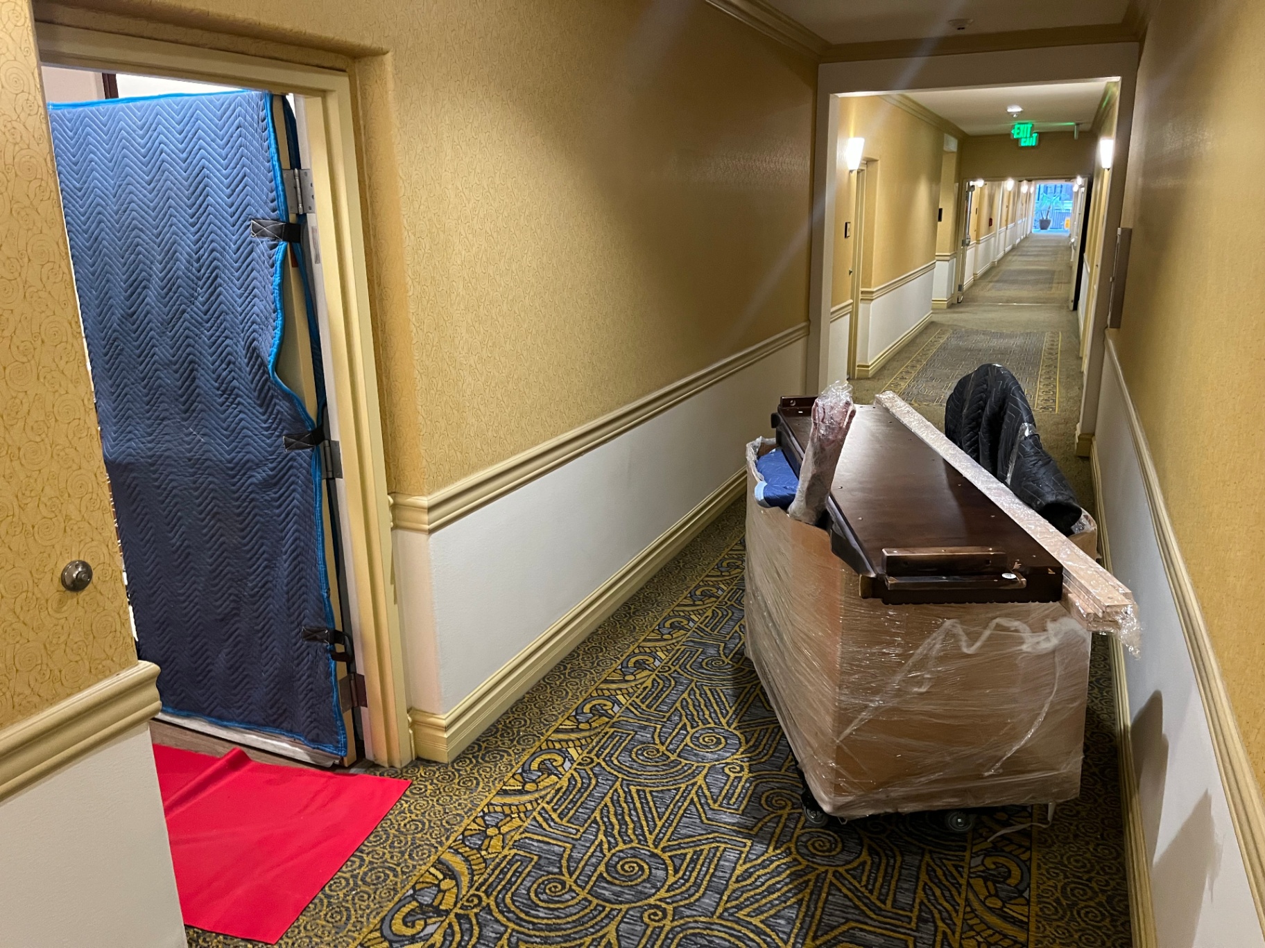 Padded furniture and door protection in a hotel hallway during a Green Echo Movers job