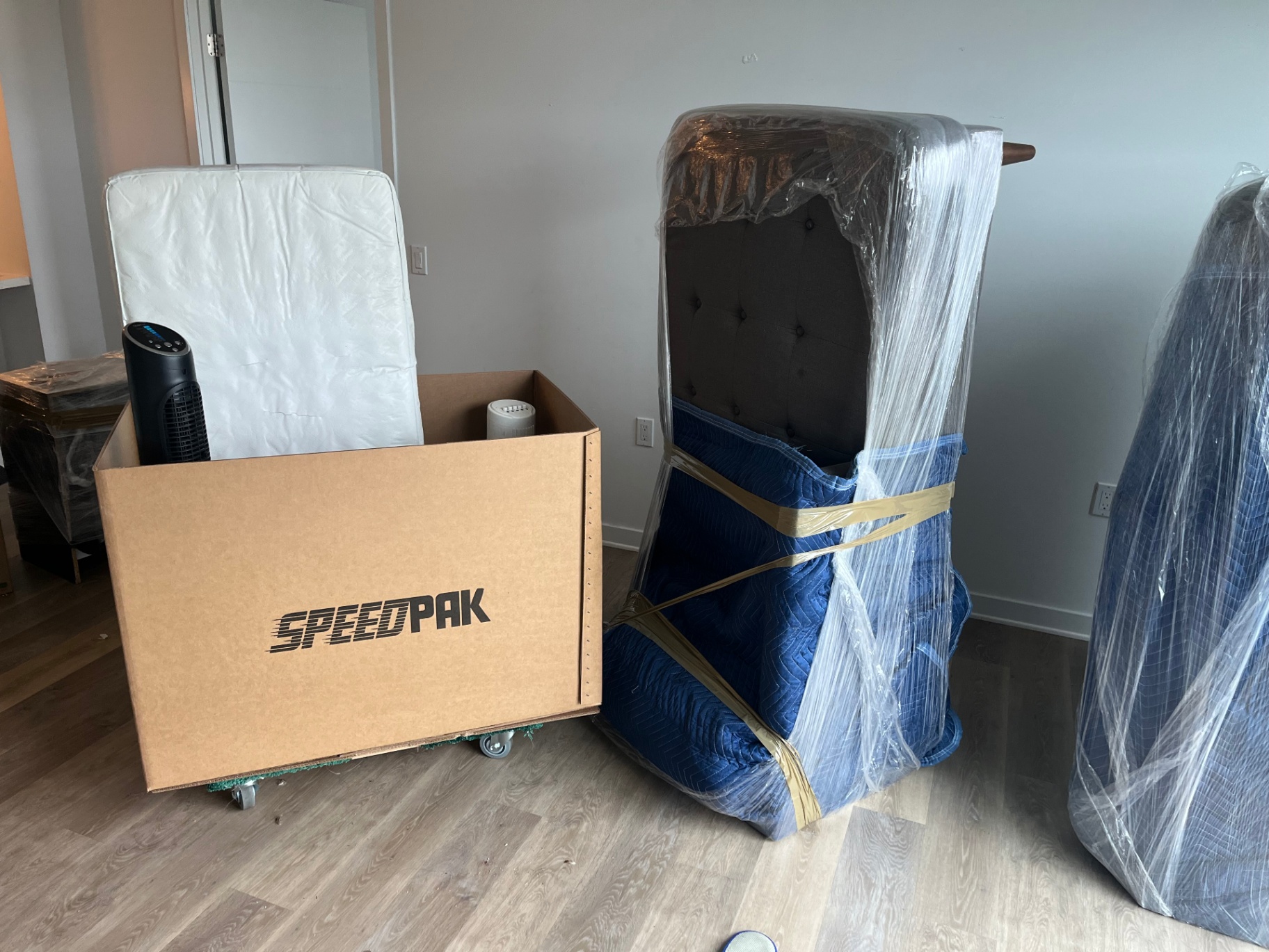 Pad-wrapped upholstered headboard and mattress prepared for safe transport