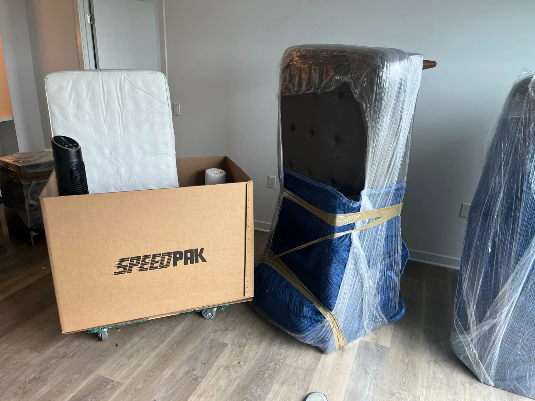 Pad-wrapped upholstered headboard and mattress prepared for safe transport