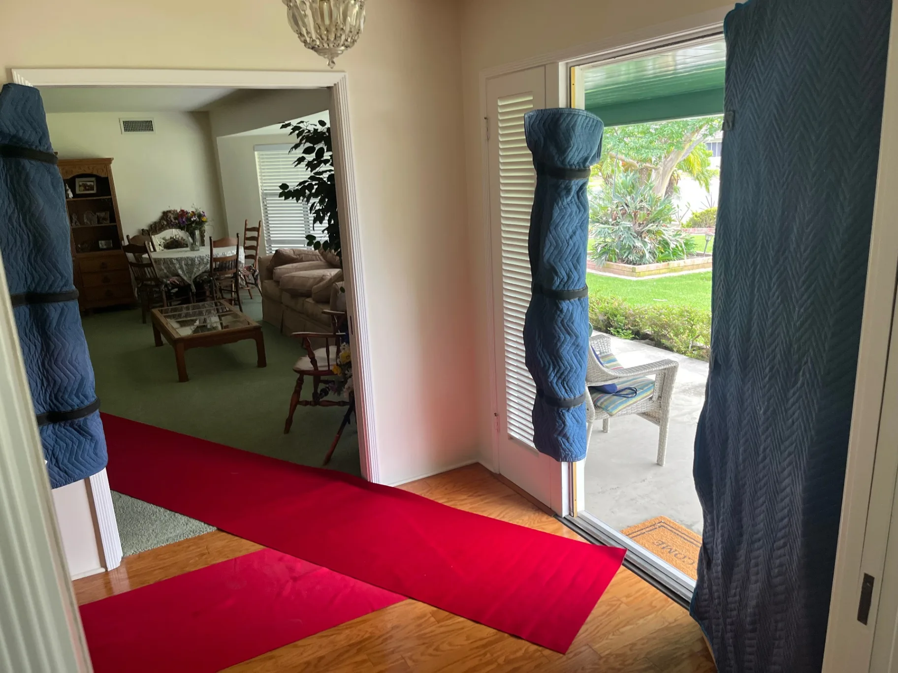 Red carpet floor runner protecting wood floors from doorway to dining room during a move